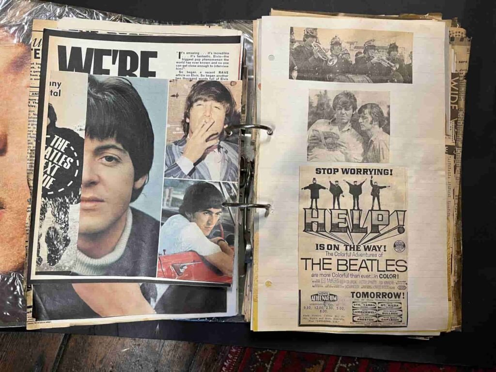 Scrapbook pages featuring The Beatles with a collage of band members' portraits on the left and vintage Help! movie advertisements on the right. 